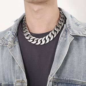 Men's wide silver Cuban link chain in matte finish shown on neck with denim jacket