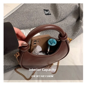 Detail view of small crescent crossbody bag interior holding phone and spray bottle