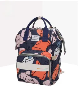 Detail of artistic abstract face print and durable top handle on stylish mommy backpack