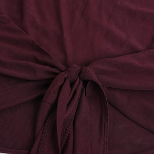 Vue détaillée du tissu en maille bordeaux avec un nœud décoratif sur le devant du haut