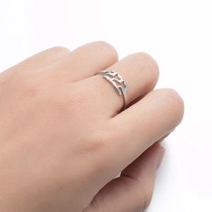Detail of silver stainless steel ring with hollow geometric patterns on finger