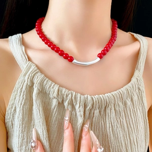 Détail du collier de perles turquoise rouges avec pendentif argenté sur mannequin