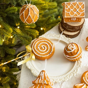 Gingerbread house and cookie ornaments set for Christmas tree decoration in warm home setting