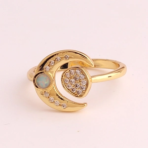 Macro detail of gold plated crescent moon ring featuring inlaid opal and cubic zirconia