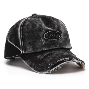 Detail of distressed denim texture and Boston embroidery on a vintage baseball cap