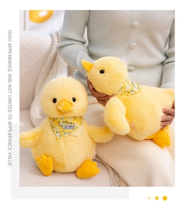 Close-up of soft yellow plush duck toy with floral Summer scarf on a white sofa