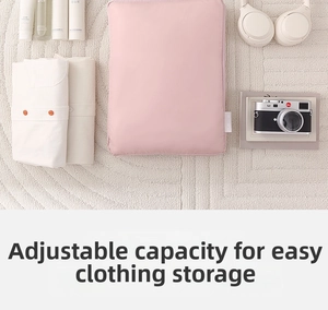 Pink waterproof travel organizer bag showing folded white clothes and luggage packing detail