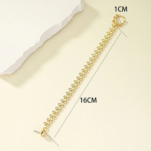 Detail of 16cm tassel chain gold earring with round sequins on beige stone background