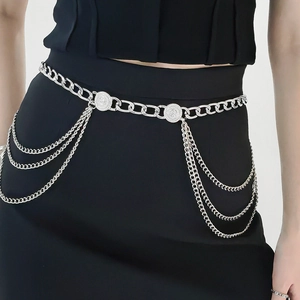 Elegant multi-layer silver metal chain belt with decorative coin buckles on a black dress