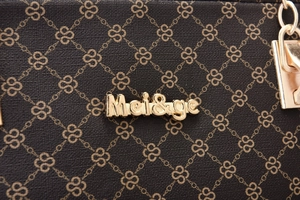 Macro detail of dark brown textured leather bag with geometric patterns and gold hardware
