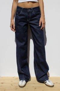 Gros plan sur la texture denim bleu foncé délavé et les coutures du jean large