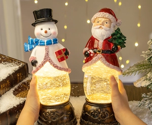 Detail of hand-held glowing Christmas lantern music box with Santa and Snowman inside