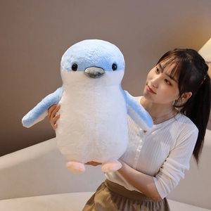 Blue and white penguin plush toy held by a model showing soft texture and medium size