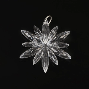 Macro detail of transparent crystalline snowflake pendant with multi-faceted petals and ring