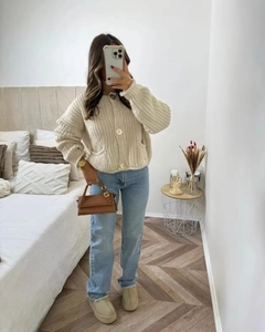 Détail du cardigan beige en grosse maille avec boutons métalliques et coupe ample