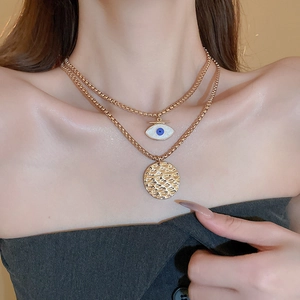 Vintage gold layered necklace with evil eye charm and hammered round pendant for women