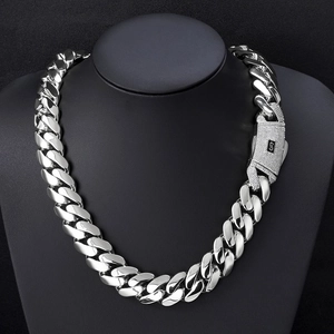 Macro view of silver cuban link chain with iced out S-logo box clasp on a bust display