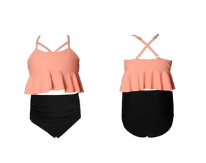 Détail du haut de bikini corail à volants et du short de bain noir à taille haute
