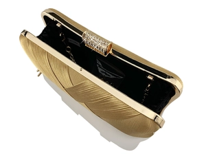 Detail of gold woven evening clutch featuring rhinestone clasp and metallic chain strap