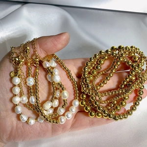 Detail of layered stainless steel gold bead bracelet with natural freshwater pearls and tag