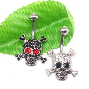 Detail view of skull belly button rings in silver and black with sparkling rhinestone eyes