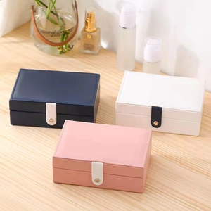 Portable leather jewelry boxes in navy, white, and pink for rings and earrings