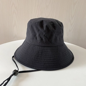 Detail of black bucket hat showing water ripple texture and adjustable windproof cord