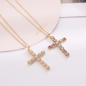 Detailed view of two gold cross necklaces with micro-pave white and multicolor zircons