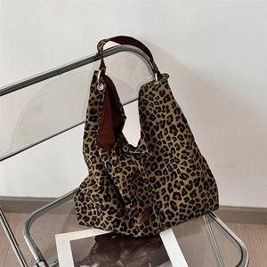 Close-up of leopard print canvas tote bag with metal logo detail and brown lining