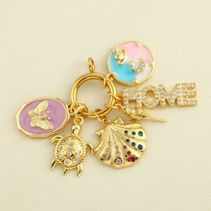 Macro view of gold 18k plated pendants featuring enamel butterfly, shell and home charms