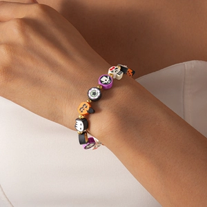 Detail of Halloween beaded bracelet featuring clay pumpkin, ghost, and skull charms