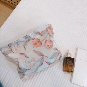 Gros plan d'une trousse de maquillage jacquard tulipe vintage sur surface blanche