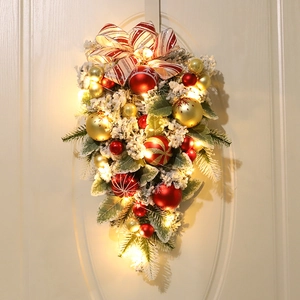 Hanging Christmas swag with red and gold baubles, LED lights and artificial snow