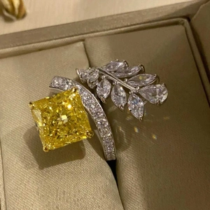Macro view of a radiant cut yellow gemstone ring with silver leaf diamond accents