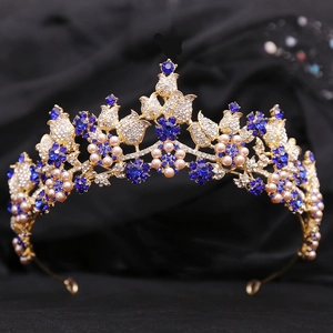 Elegant gold bridal crown featuring blue crystals and white pearls on a black background