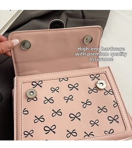 Dettaglio ravvicinato della borsa rosa con stampa a fiocco nero e chiusure magnetiche argento