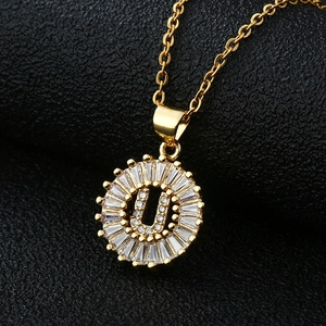 Gros plan du pendentif lettre U doré avec zircons baguette sur une chaîne fine