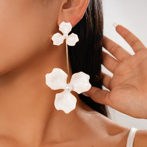 Detail of bohemian white flower earrings with pearls and gold stems on model