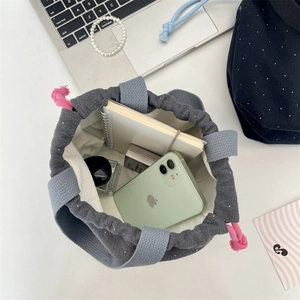 Internal view of gray polka dot drawstring bag showing capacity for phone and notebook