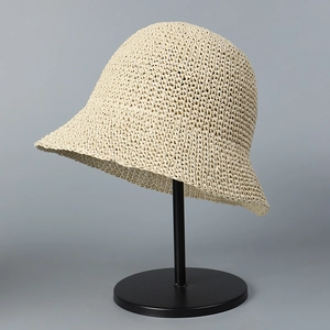 Detail of hand-woven cream straw sun hat showing intricate texture and curved brim