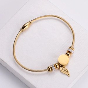 Gold wire bangle with magnetic clasp, round charm and zircon angel wing pendant