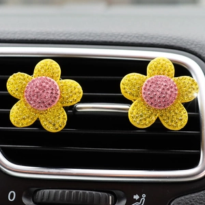 Detail of yellow flower car air vent clips with pink centers and sparkling rhinestones