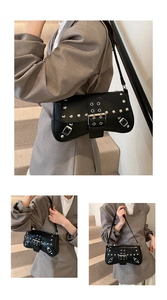 Detail of black motorcycle shoulder bag featuring silver metal rivets and buckle straps
