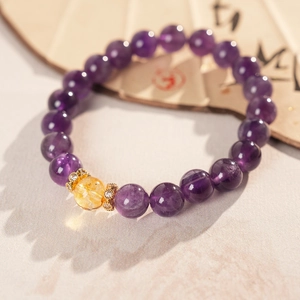 Detailed macro view of purple and yellow crystal beads with golden rhinestone spacers on a fan