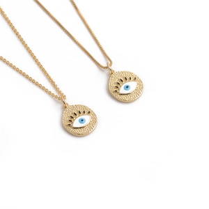 Détail de colliers dorés avec pendentifs cœur oeil bleu maléfique et finition texturée