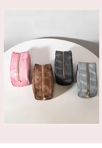 Detail of suede makeup bags in four colors with decorative star-shaped metal zippers