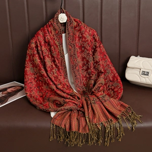 Detail view of red cashmere pashmina with gold paisley pattern and tassel fringe