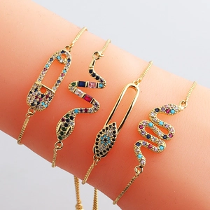Adjustable gold plated charm bracelets featuring colorful cubic zirconia eyes and snakes
