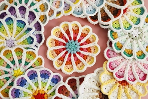 Close-up detail of handmade crochet coasters showing colorful yarn textures and knit stitches