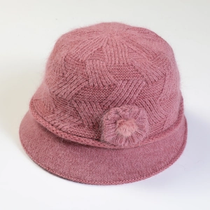 Detailed top view of pink knitted hat showing soft wool texture and pompom decoration